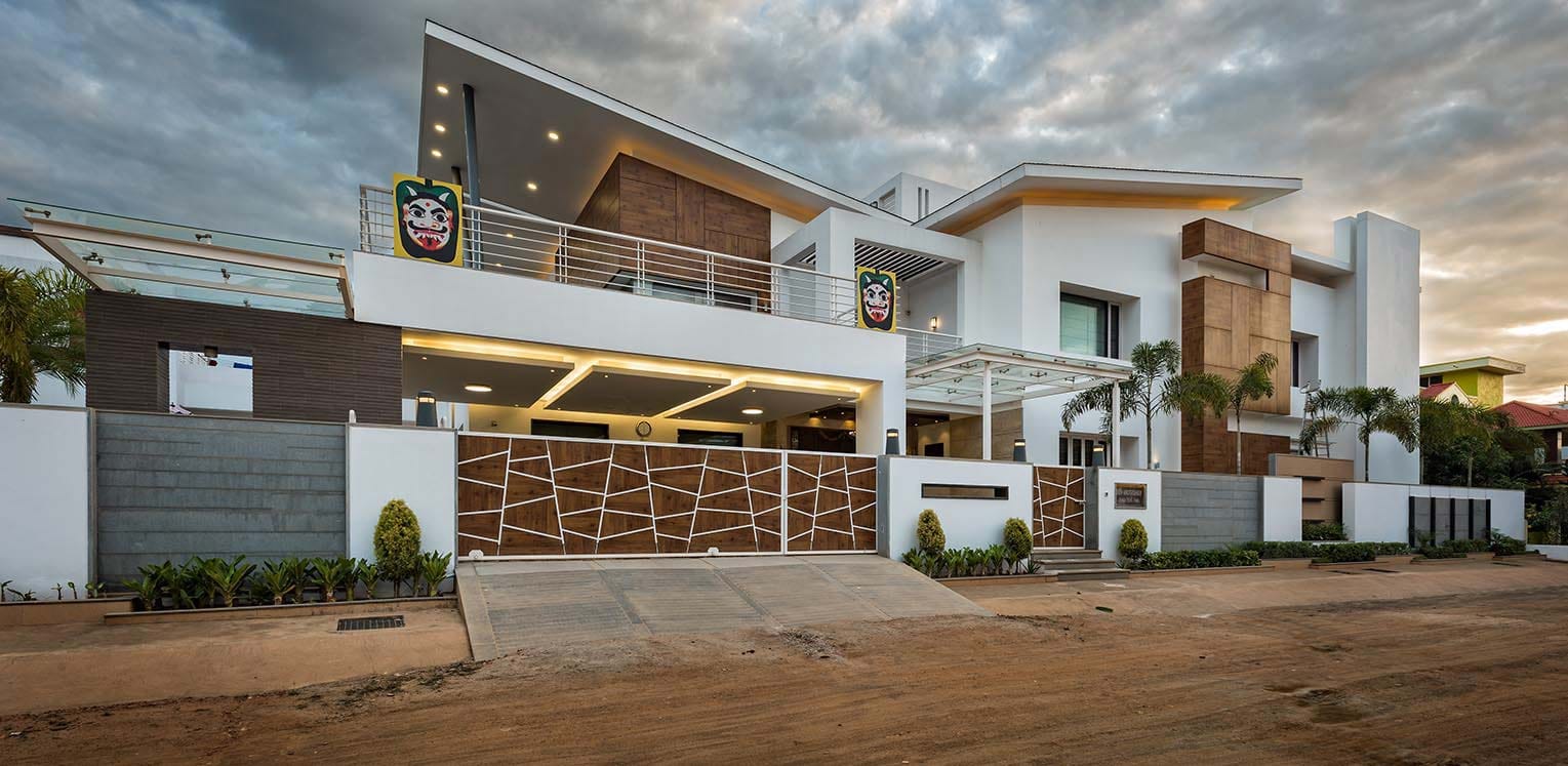 Luxury contemporary villa with cantilevered roof and wood-clad volumes at dusk
